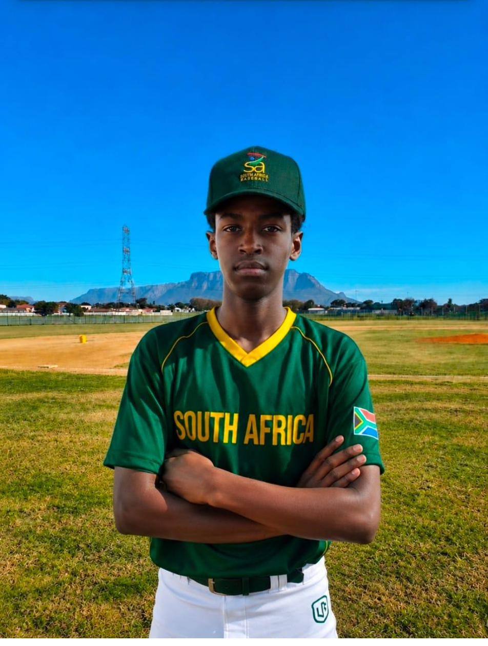 Tinashe Mutseka in South Africa national baseball colours, arms crossed, Table Mountain behind him